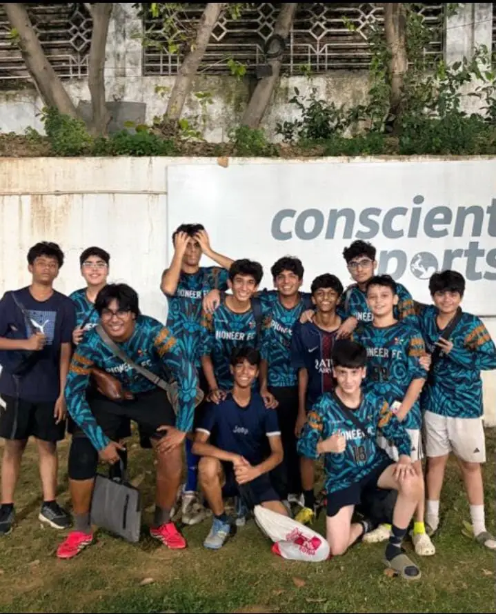 Pioneer FC youth football team in teal patterned jerseys with Pioneer FC on the chest